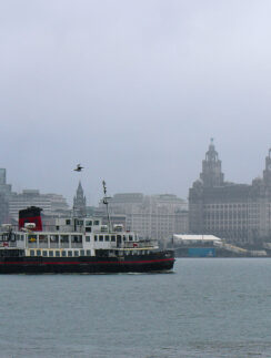 a boat in the water with a city in the background