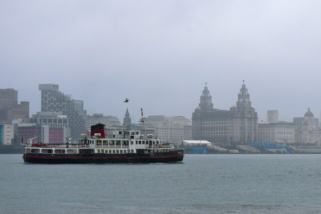 a boat in the water with a city in the background