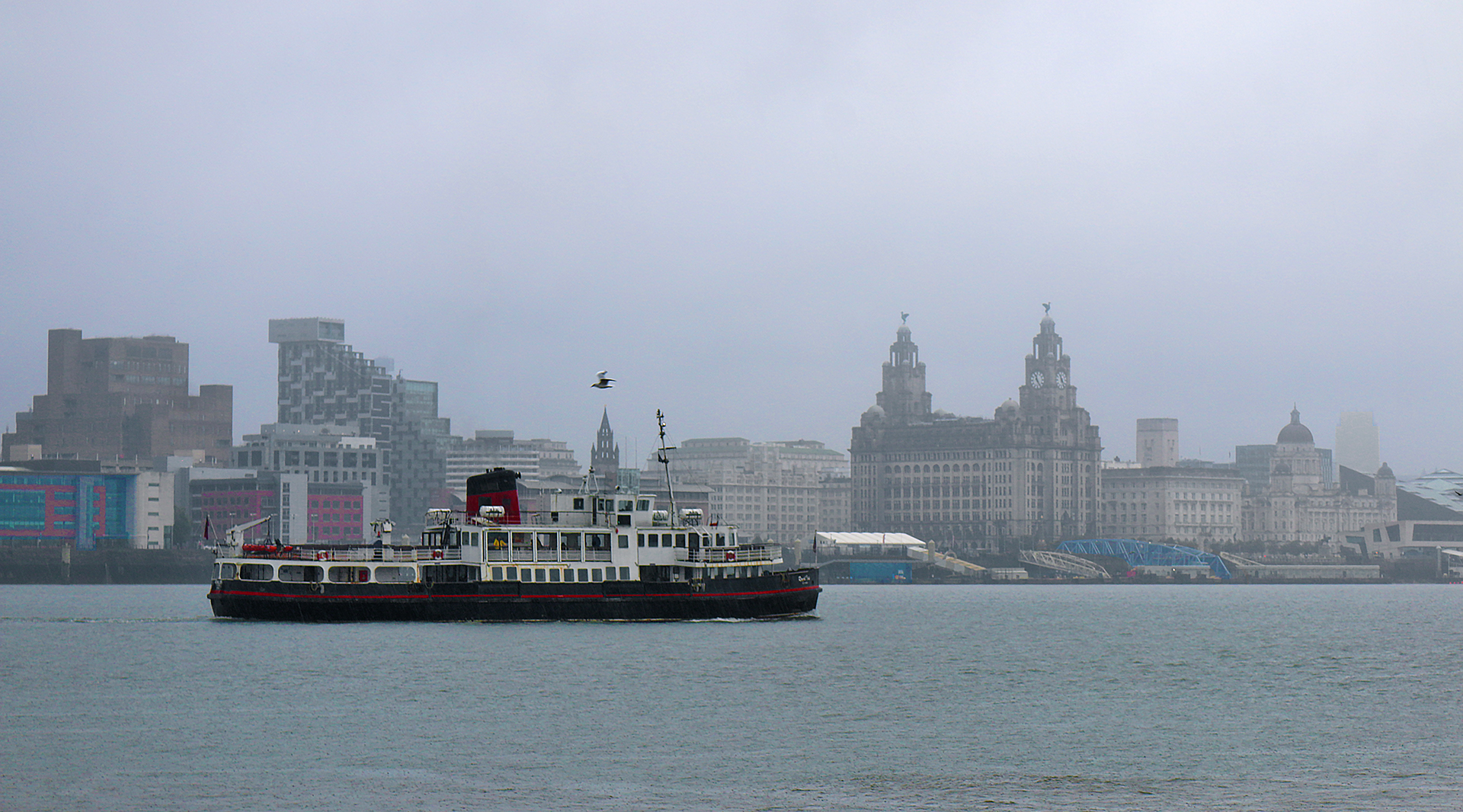 a boat in the water with a city in the background