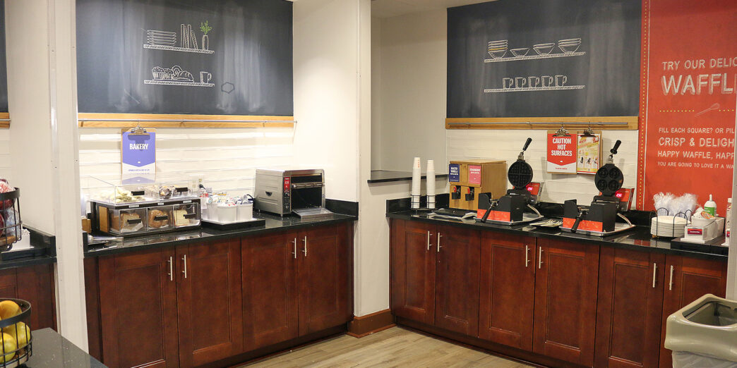 a coffee shop with wood cabinets and black counter tops