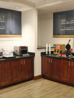 a coffee shop with wood cabinets and black counter tops