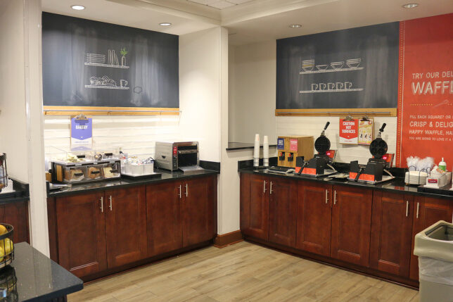 a coffee shop with wood cabinets and black counter tops