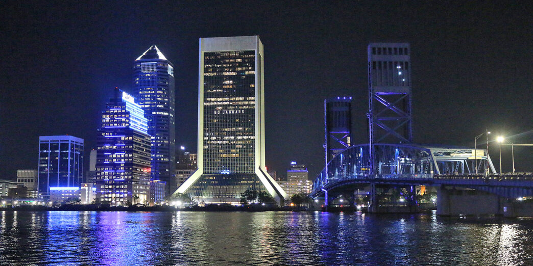 a city skyline at night with a bridge and a bridge