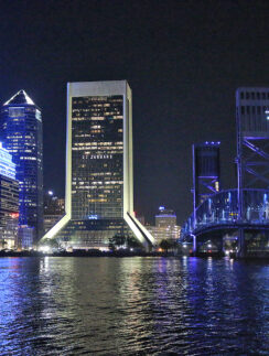 a city skyline at night with a bridge and a bridge