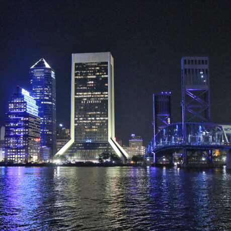 a city skyline at night with a bridge and a bridge