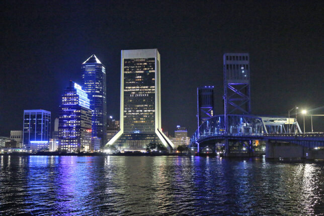 a city skyline at night with a bridge and a bridge