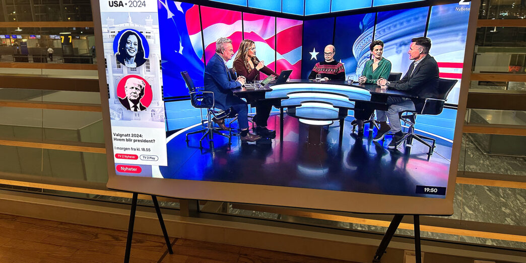 a television screen with people sitting at a table