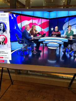 a television screen with people sitting at a table