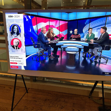 a television screen with people sitting at a table