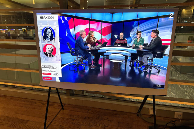 a television screen with people sitting at a table