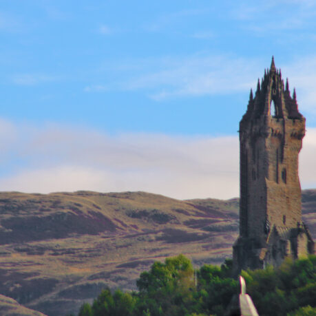 a stone tower with a steeple and trees in the background