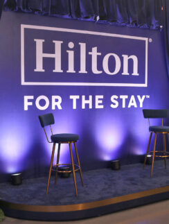 a blue stage with chairs and a blue curtain