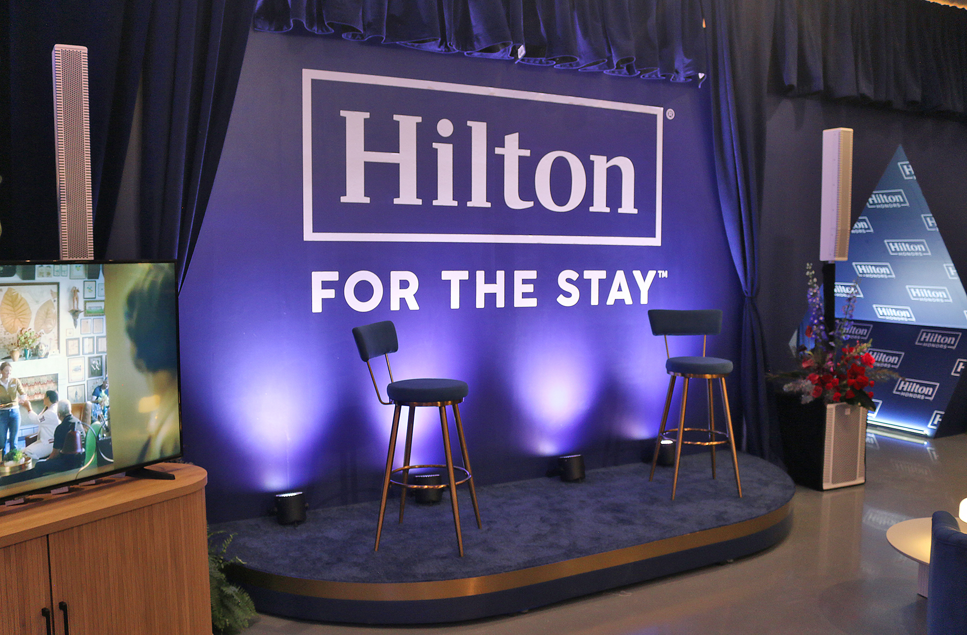 a blue stage with chairs and a blue curtain