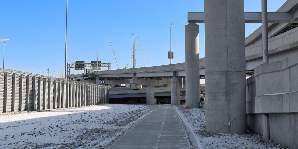 a concrete walkway with pillars and snow
