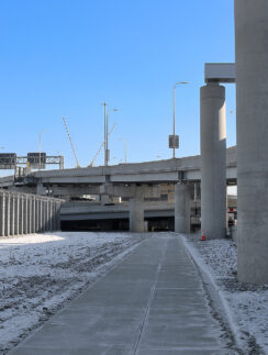 a concrete walkway with pillars and snow