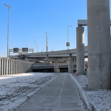 a concrete walkway with pillars and snow