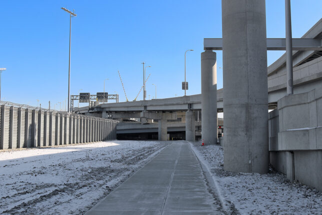 a concrete walkway with pillars and snow