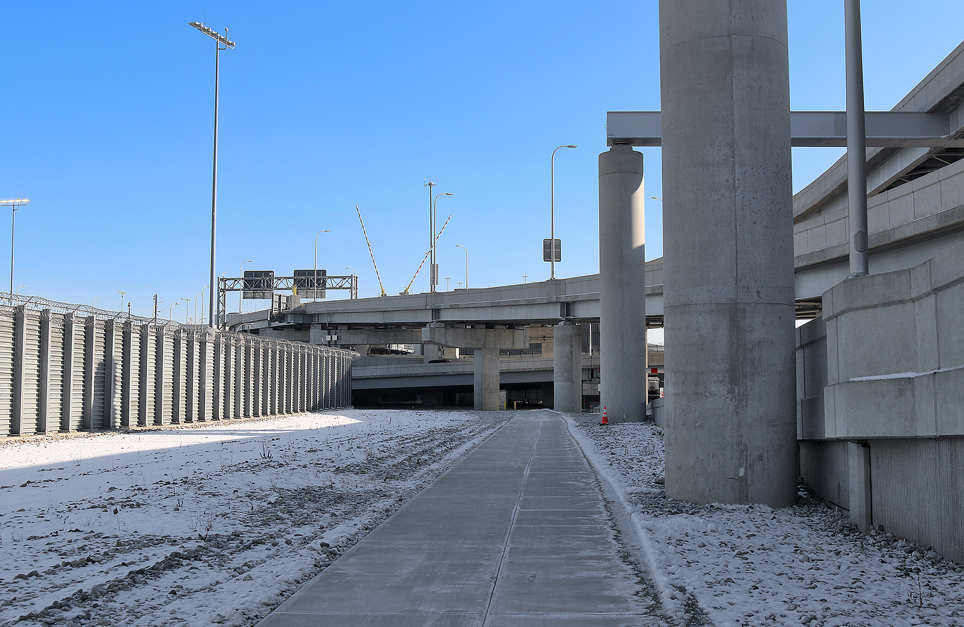 a concrete walkway with pillars and snow