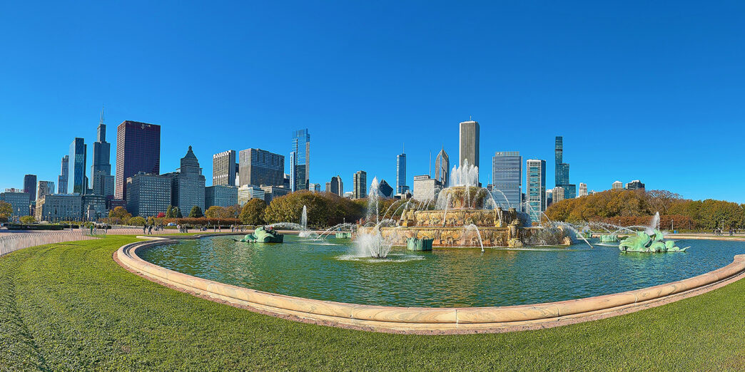 a fountain in a park with a city in the background