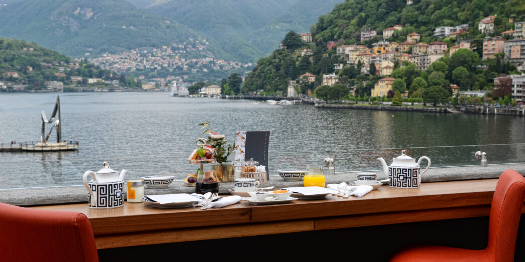 a table with a view of a lake and mountains in the background