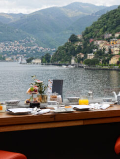 a table with a view of a lake and mountains in the background