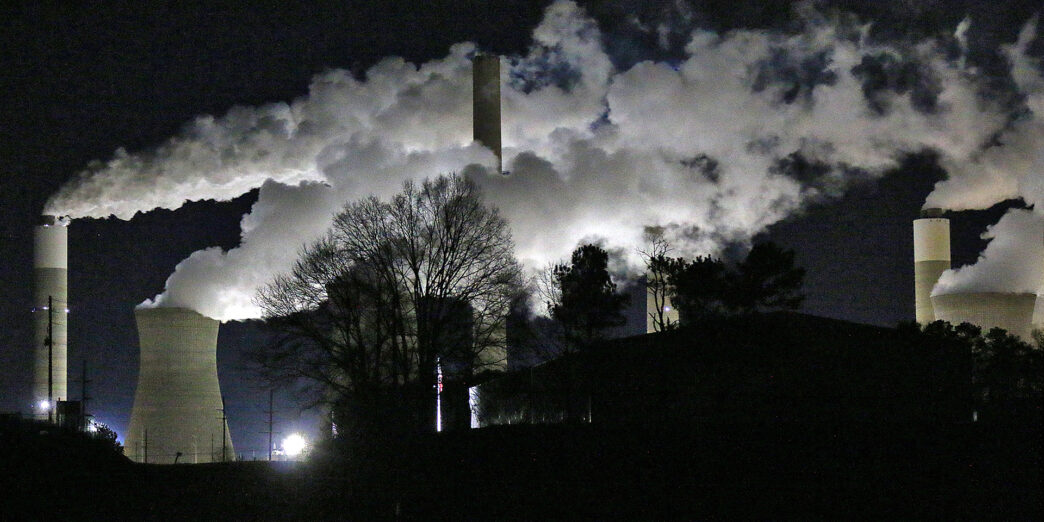 a factory with smoke coming out of it at night