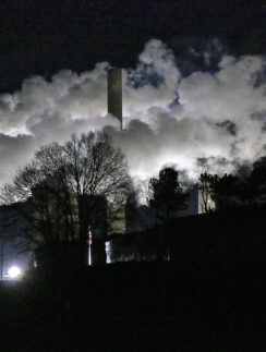 a factory with smoke coming out of it at night