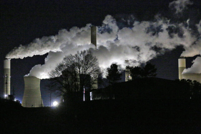 a factory with smoke coming out of it at night