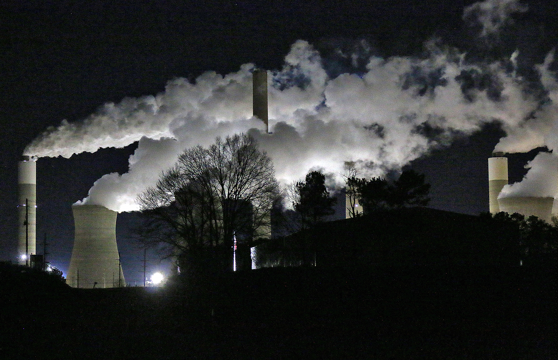 a factory with smoke coming out of it at night