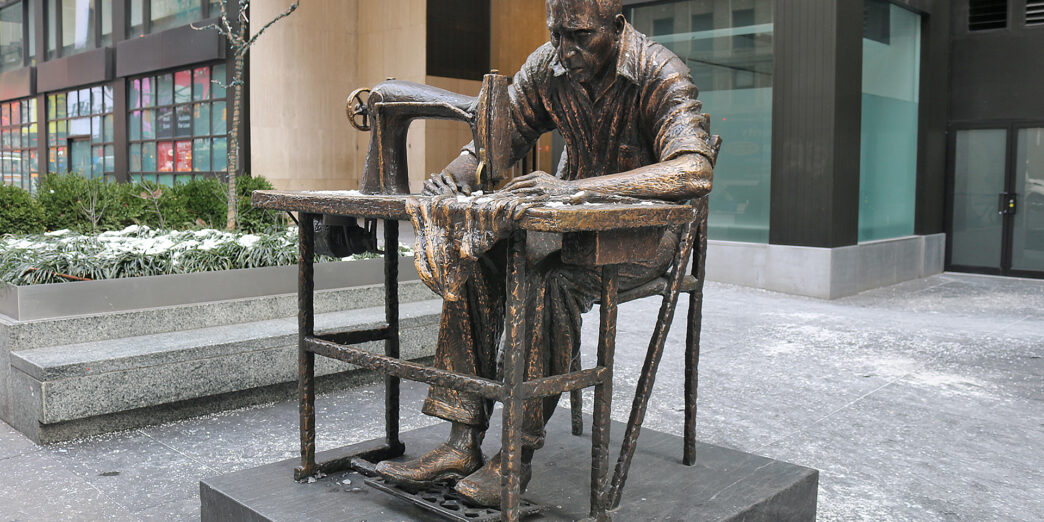a statue of a man sewing on a chair
