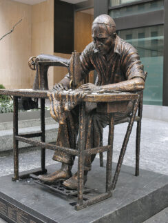 a statue of a man sewing on a chair