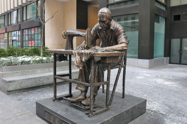 a statue of a man sewing on a chair