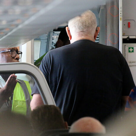 a man standing in a room with a door open