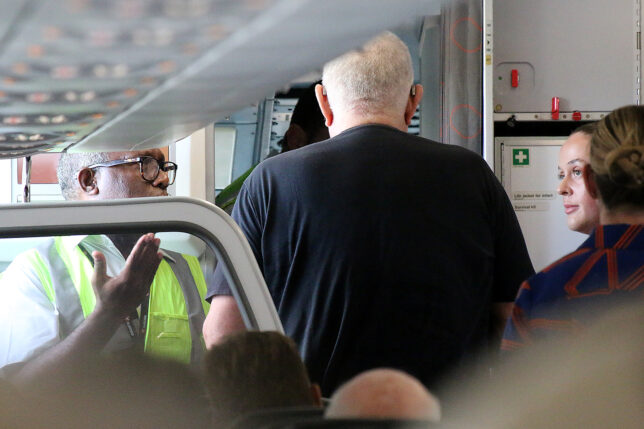 a man standing in a room with a door open