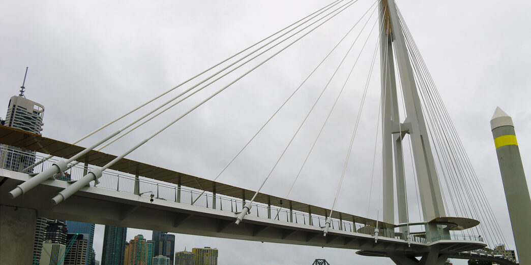 a bridge over water with a city in the background