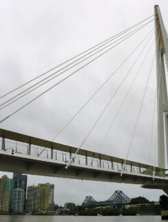 a bridge over water with a city in the background