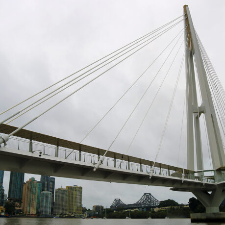 a bridge over water with a city in the background