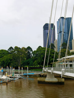 a bridge over a river with a body of water and a city in the background
