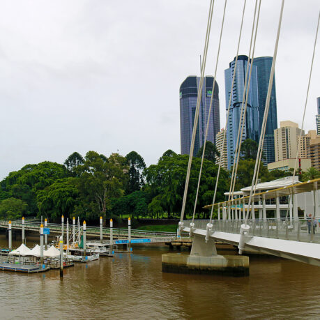 a bridge over a river with a body of water and a city in the background