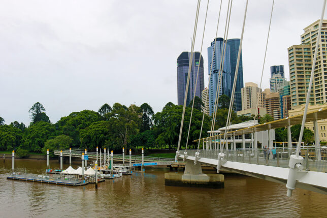a bridge over a river with a body of water and a city in the background