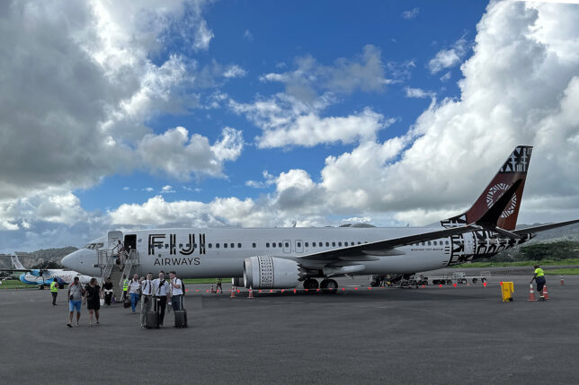 a group of people standing next to a large airplane