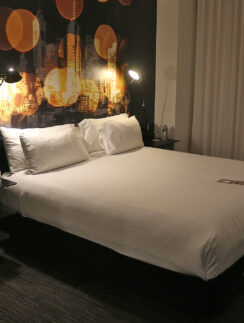 a bed with white sheets and a night stand