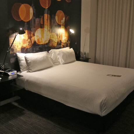 a bed with white sheets and a night stand