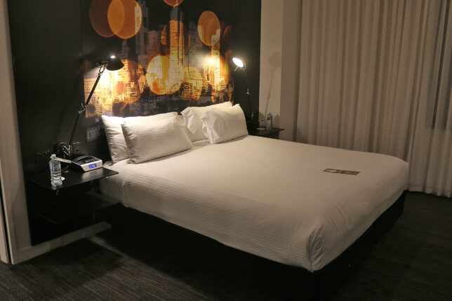 a bed with white sheets and a night stand