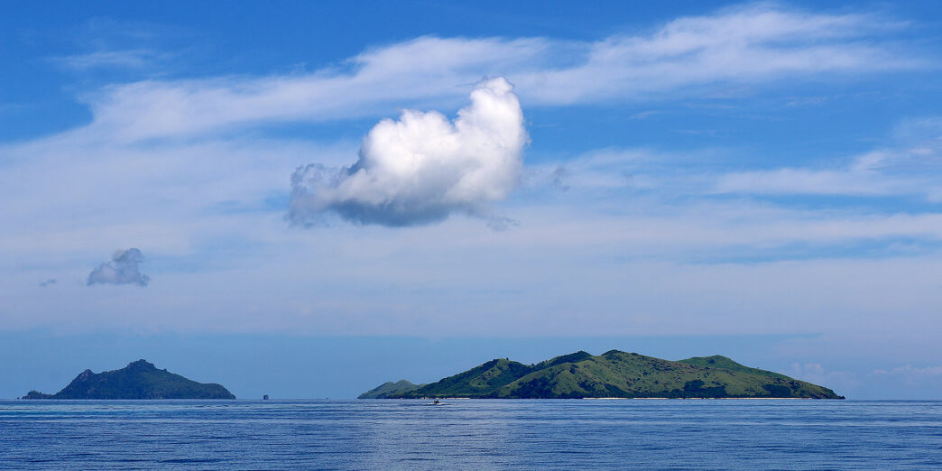 a body of water with a white cloud above it