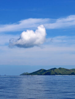 a body of water with a white cloud above it