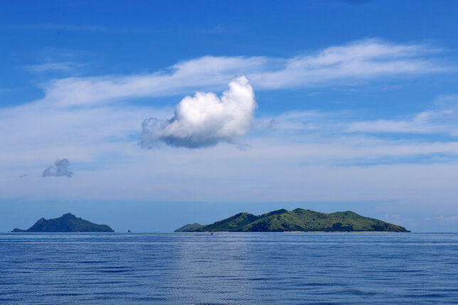 a body of water with a white cloud above it