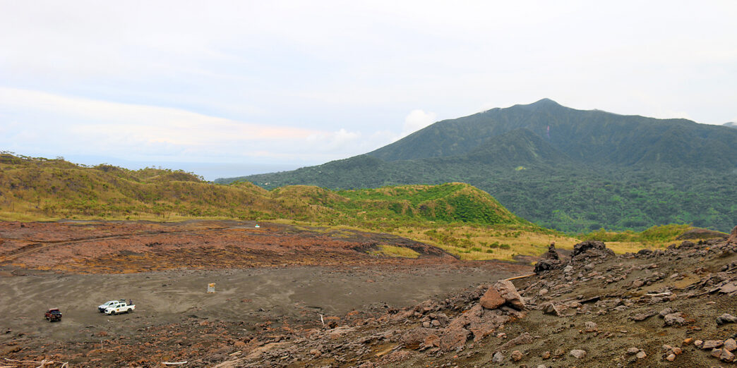 a dirt field with mountains in the background