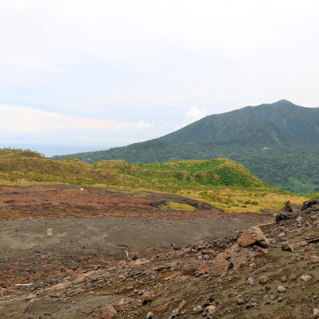 a dirt field with mountains in the background