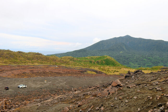 a dirt field with mountains in the background